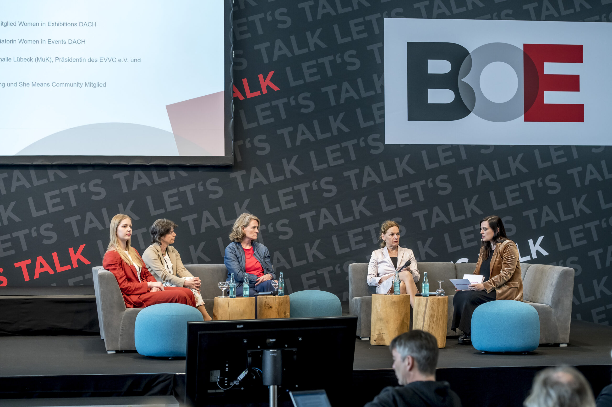 Foto vom Podium mit den vier Diskutantinnen Linda Eifert, Ilona Jarabek, Kerstin Hoffmann-Wagner, Sabine Loos und der Moderatorin Karin Ruppert (von links nach rechts). Im Hintergrund ist groß das Logo der BOE zu sehen.