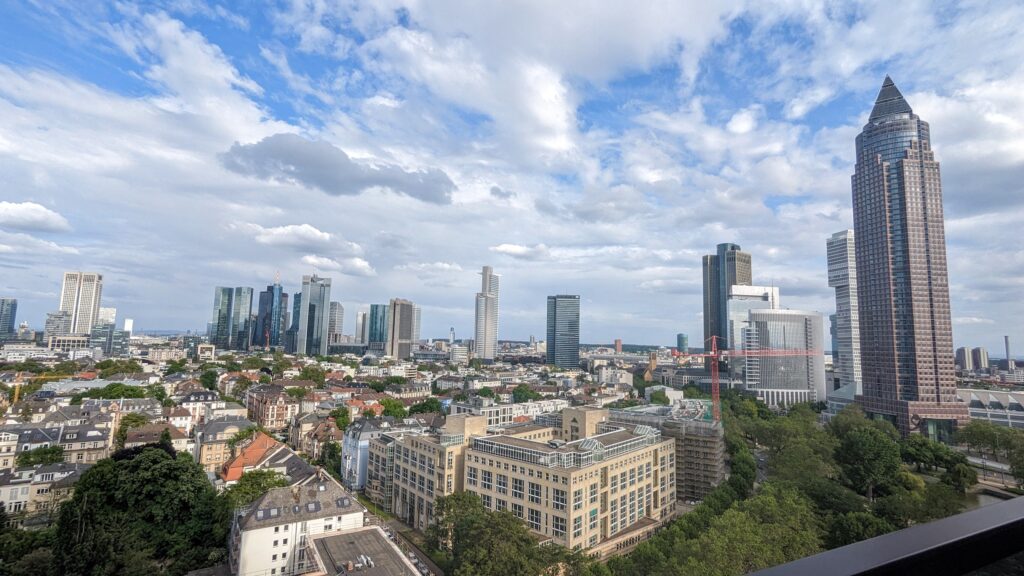Die Fotos zeigen Teilnehmerinnen des Live-Meetups in Frankfurt auf dem Balkon des Melia City Frankfurt im 15. Stock mit Sicht auf die Frankfurter Skyline.
